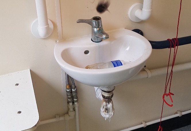 Toilet sink with the waste trap melted and wall burned behind it