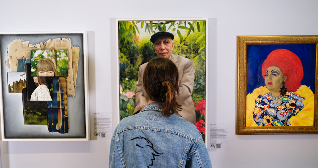 Visitor looking at the three commissioned portraits in the Mirror Mirror exhibition