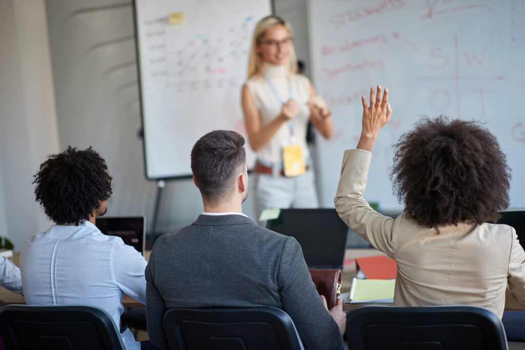 People asking questions at an in-person training event