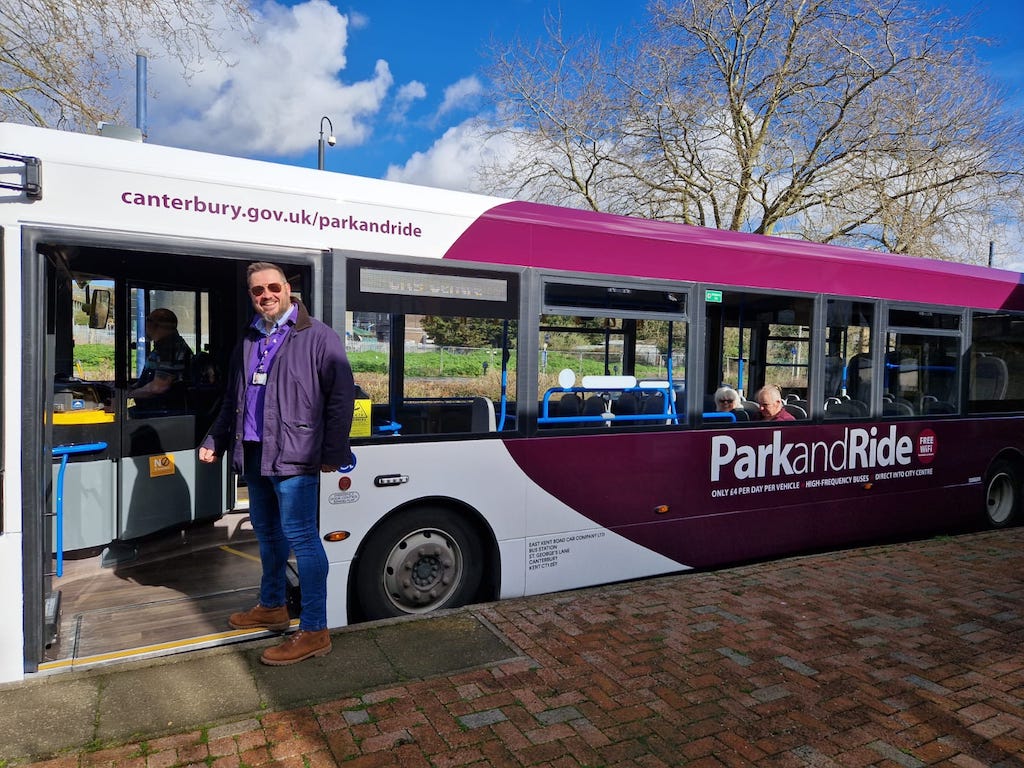 Cllr Alex Ricketts standing next to a Park and Ride bus