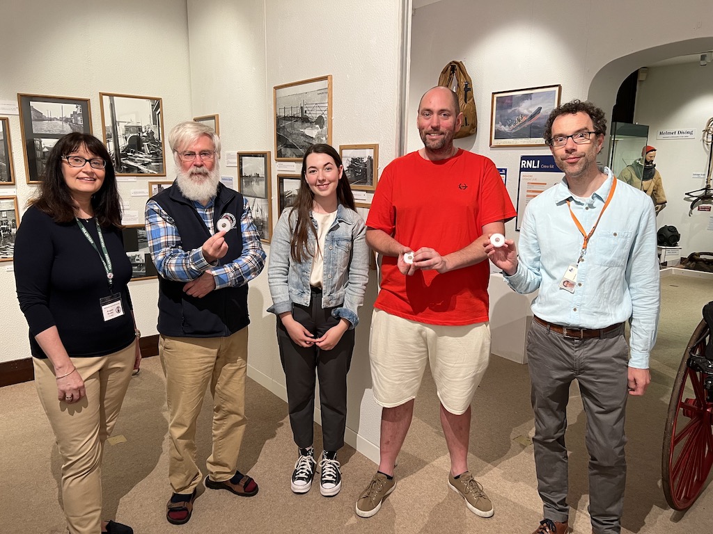 Group photo of Angela Boddy and Peter Banbury (Trustees of Whitstable Museum and Gallery), Isabelle Diggle (Finds Liaison Officer), Jason Reilly (Finder of the coins) and Craig Bowen (Collections and Learning Manager, Canterbury Museums & Galleries) holding the three gold staters at Whitstable Museum