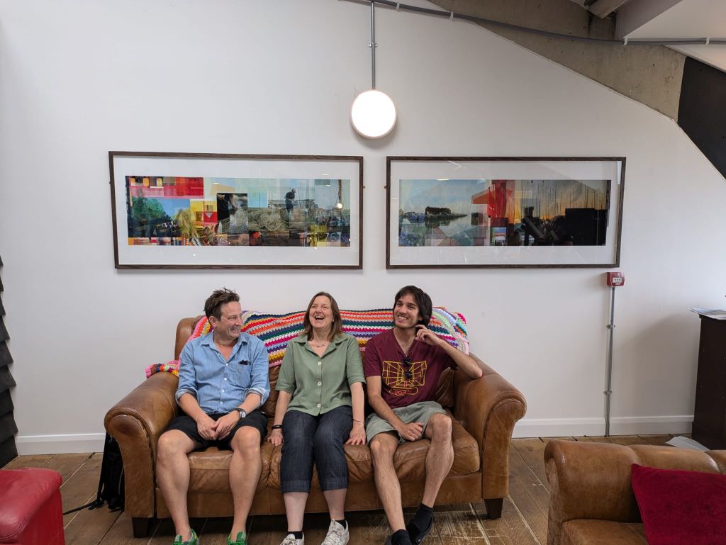 Artist Phil Miller, Cllr Clare Turnbull and art panel member Robin Louis sitting on a sofa below the new artwork