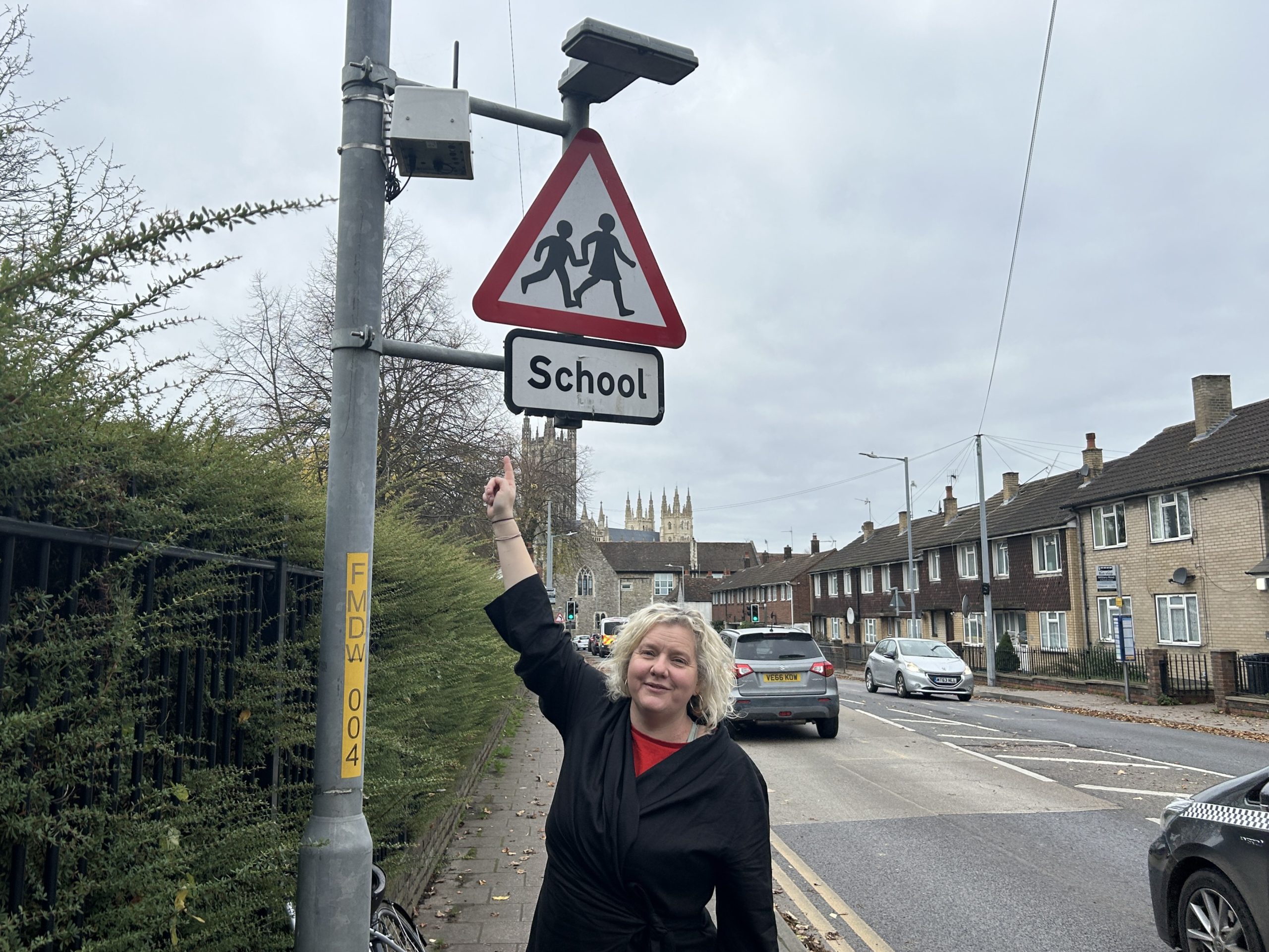 Cllr Mel Dawkins pointing at an air quality sensor installed on a lamp post