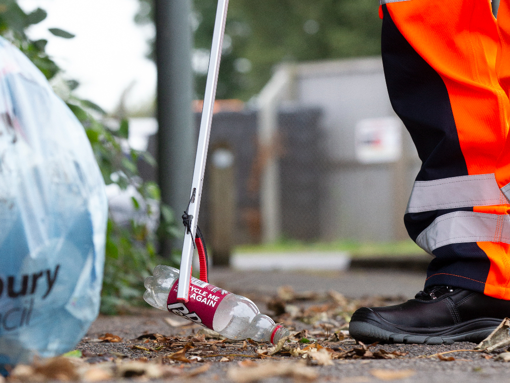 Canenco staff picking up a plastic bottle on the floor