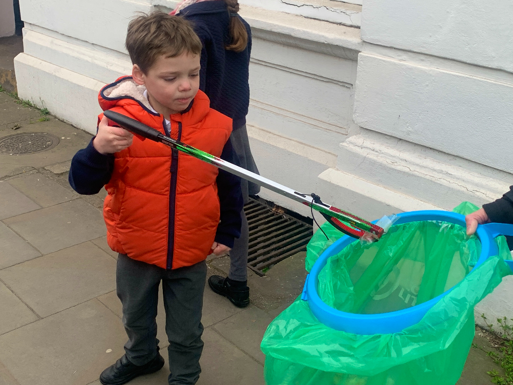 Tom putting litter in a plastic bag